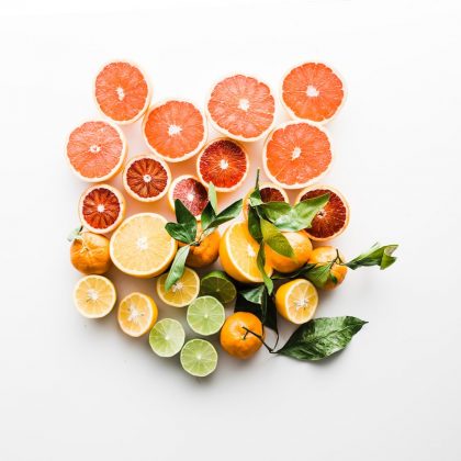 A pile of sliced ruby grapefruits, oranges, limes, and mandarins