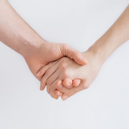 Two people hold hands