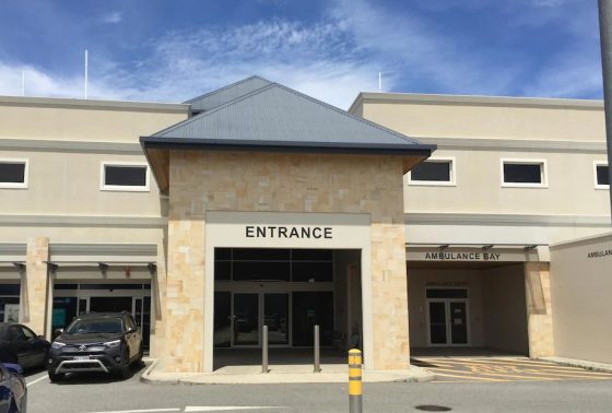 The Entrance to Brecken Health Bunbury's After Hours Clinic has a dark-gray coloured roof and cream-coloured walls. The Entrance area is next to the Ambulance Bay and a car park area
