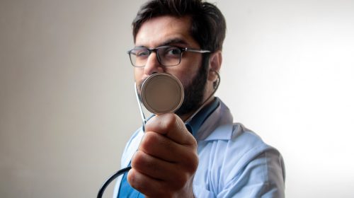 A doctor holds up a stethoscope