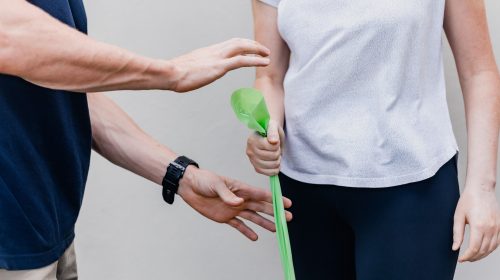 A physiotherapist directs a patient on how to use a resistance band