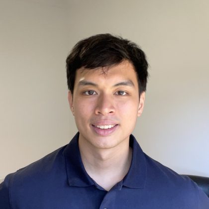 Nathaniel Bongon smiles at the camera whilst wearing a navy polo shirt