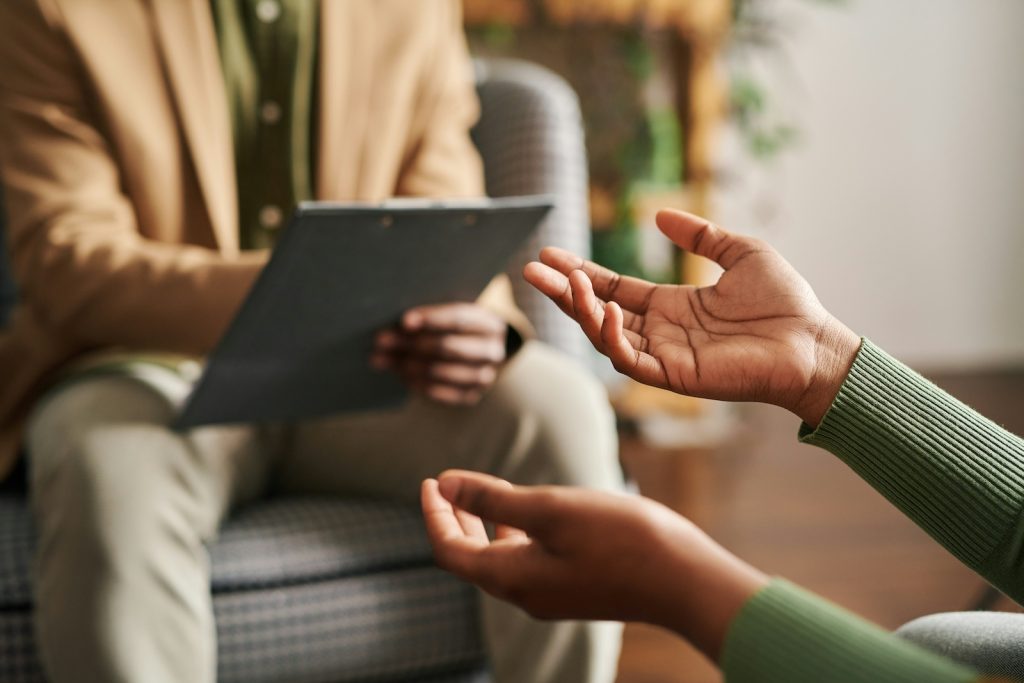 person talking to a mental health professional. Both sitting calmly