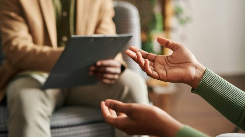 person talking to a mental health professional. Both sitting calmly