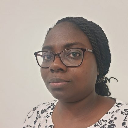 Dr Rhoda Olaleru smiles at the camera. She has dark hair that is tied back and is wearing dark glasses.