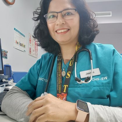 Dr Jasmin Bartolome smiles at the camera. She has medium length dark hair and is wearing clear glasses